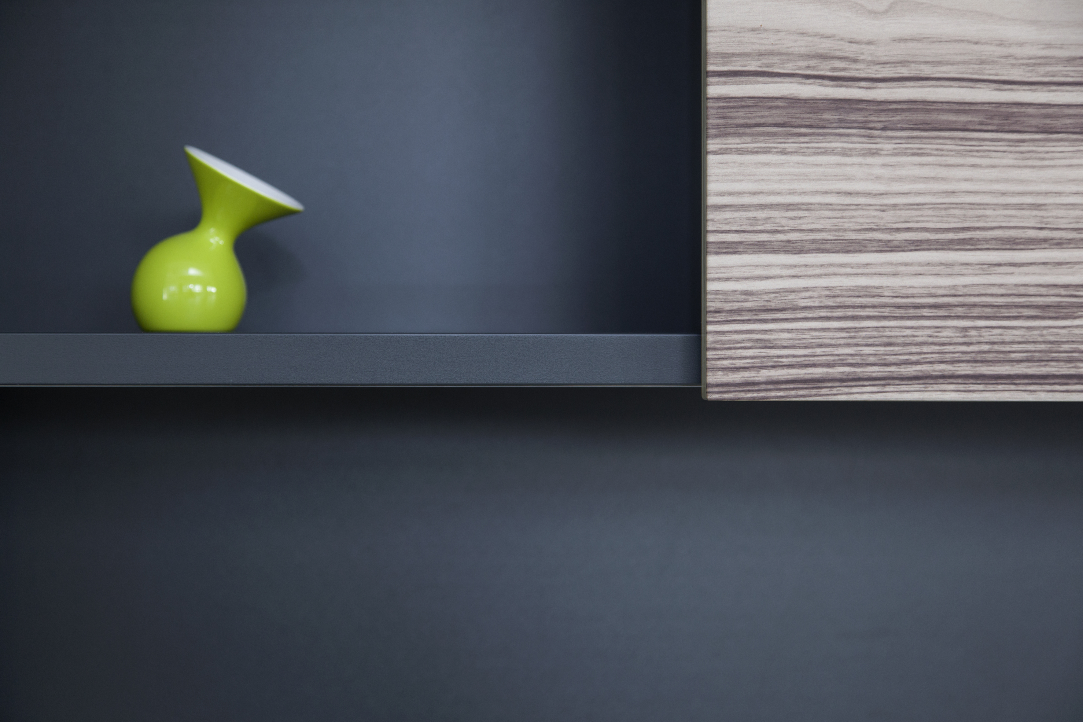 Detail Regalwand schwarz Holz mit grüner Vase