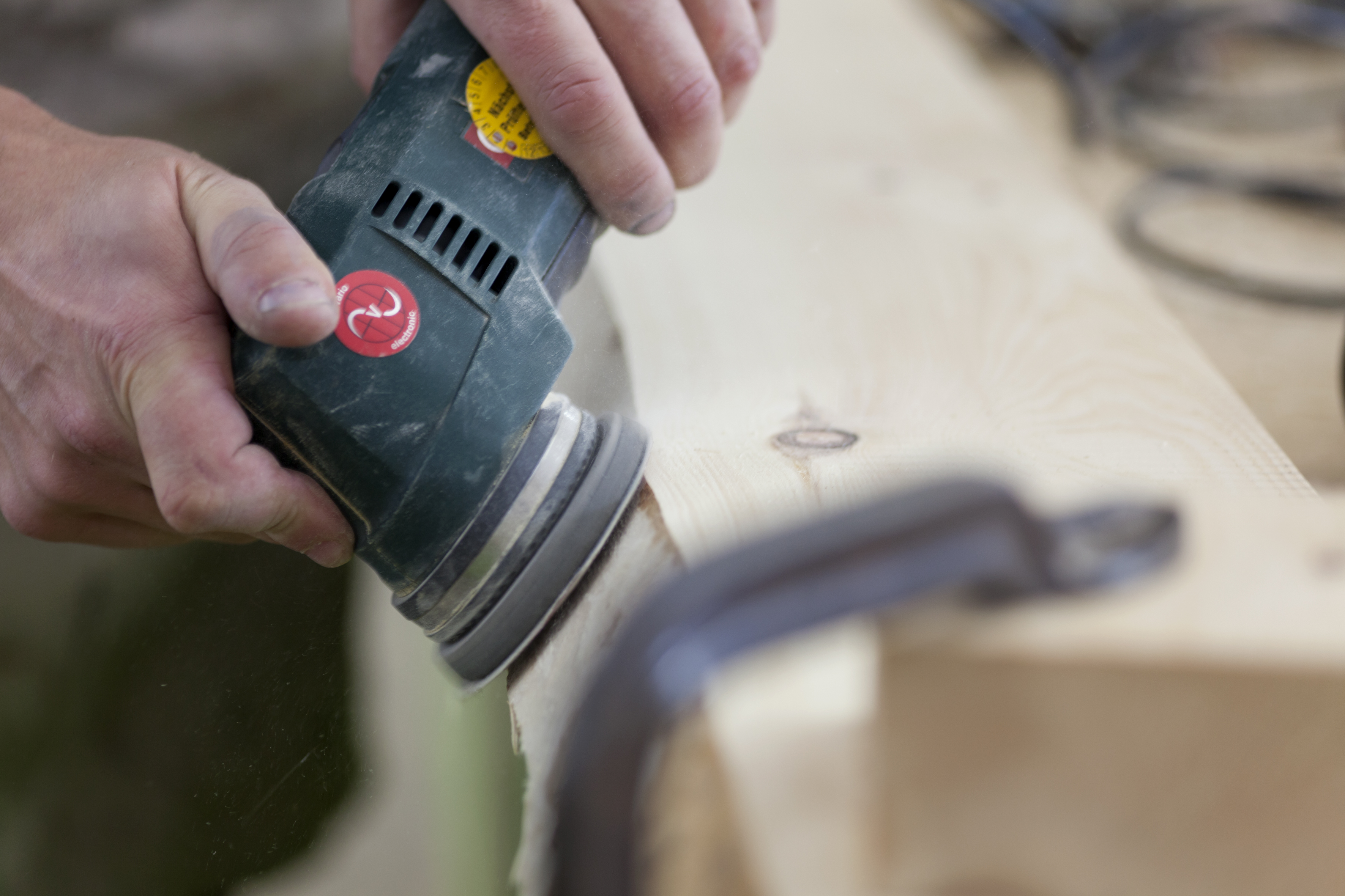 Detail Hände bearbeiten mit Schleifmaschine Holzstück
