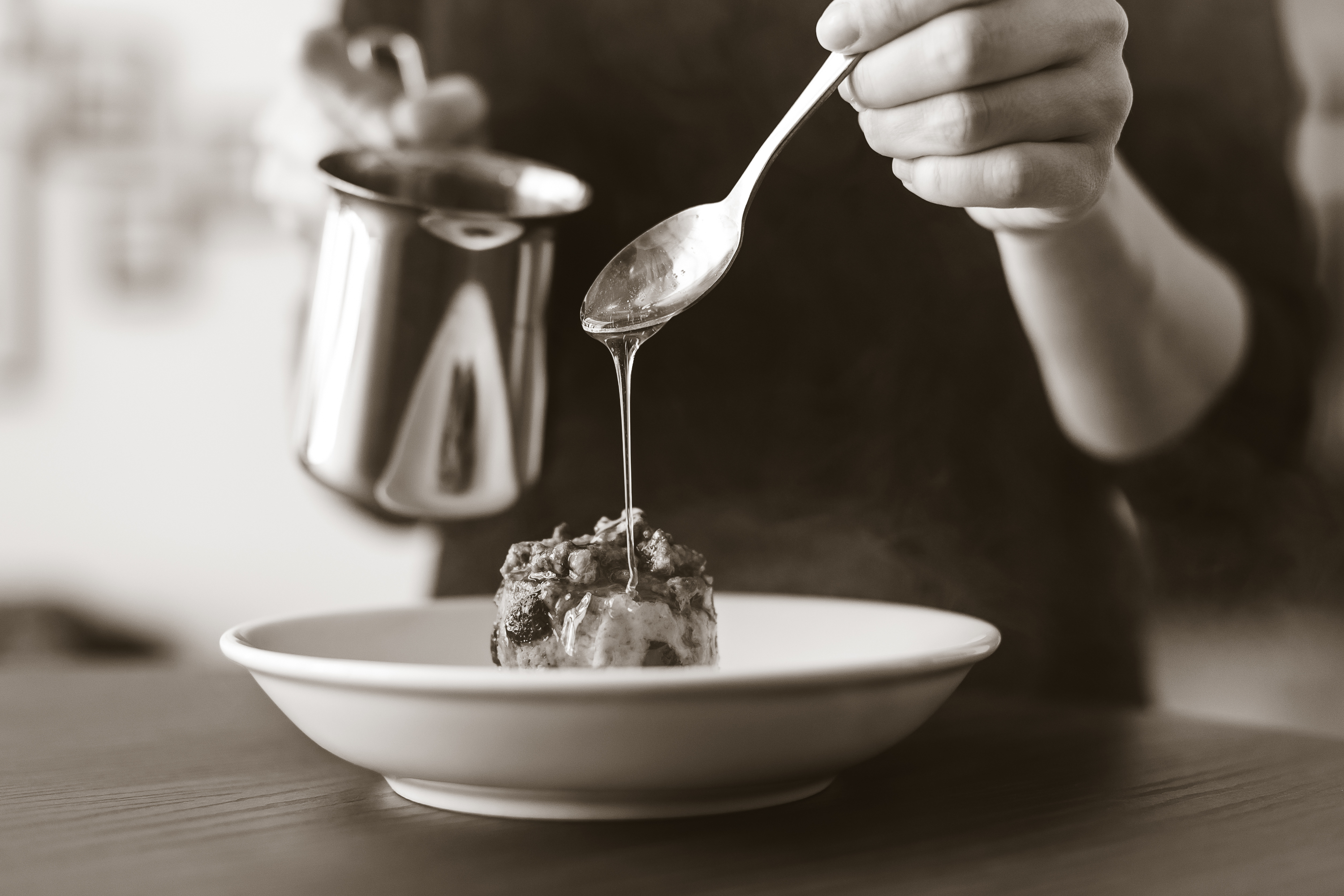Hand mit Löffel über Speisenteller