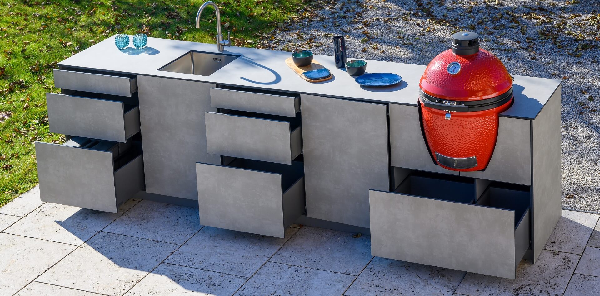 Graue Outdoor-Küche mit rotem Grill in Eiform