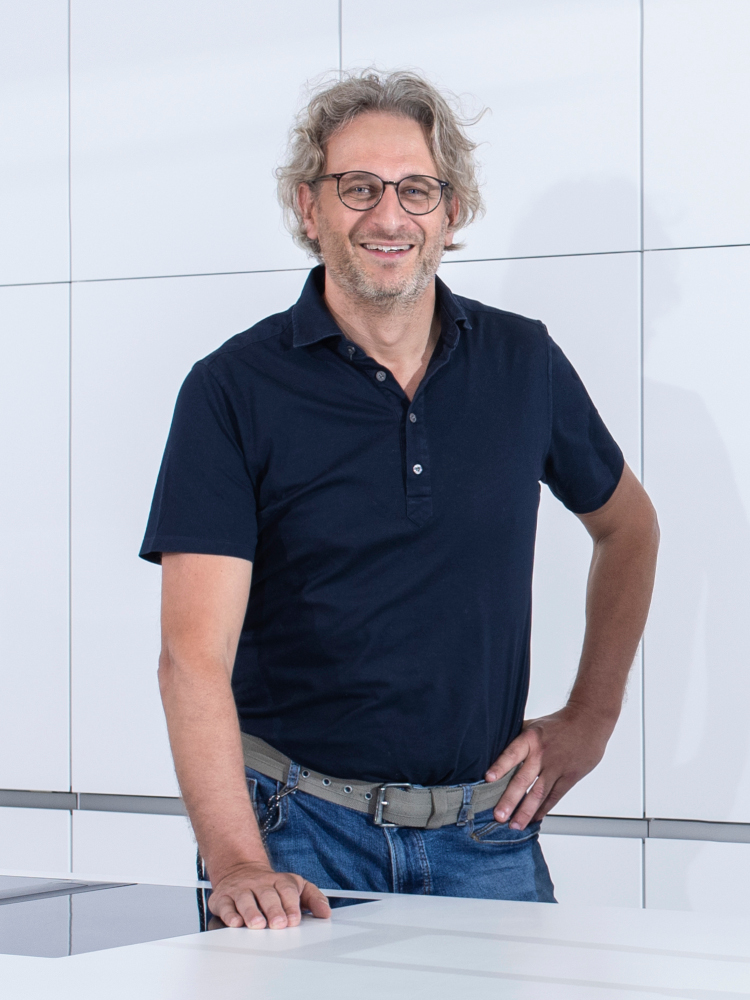 Porträt von Sascha Riks in einer weißen Küche