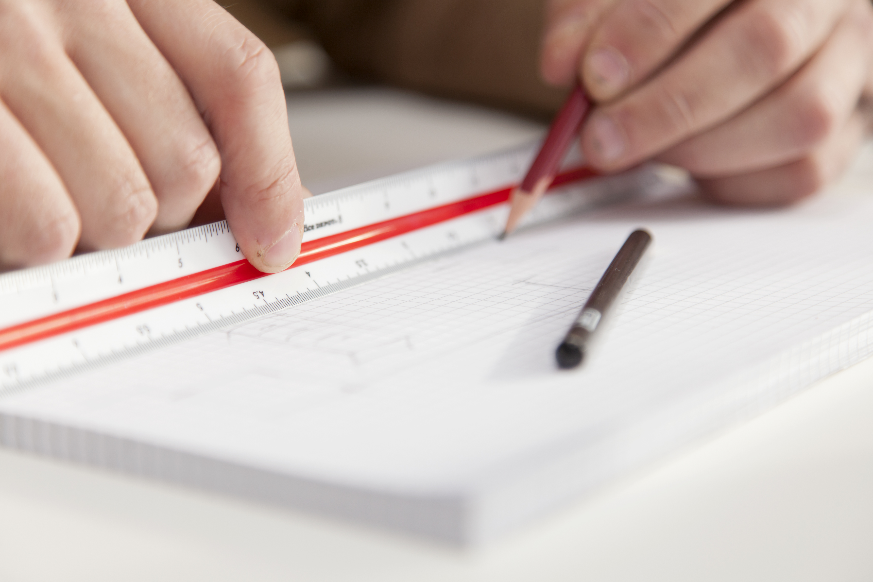Detail Hände ziehen mit Lineal und Bleistift einen Strich auf einem Block