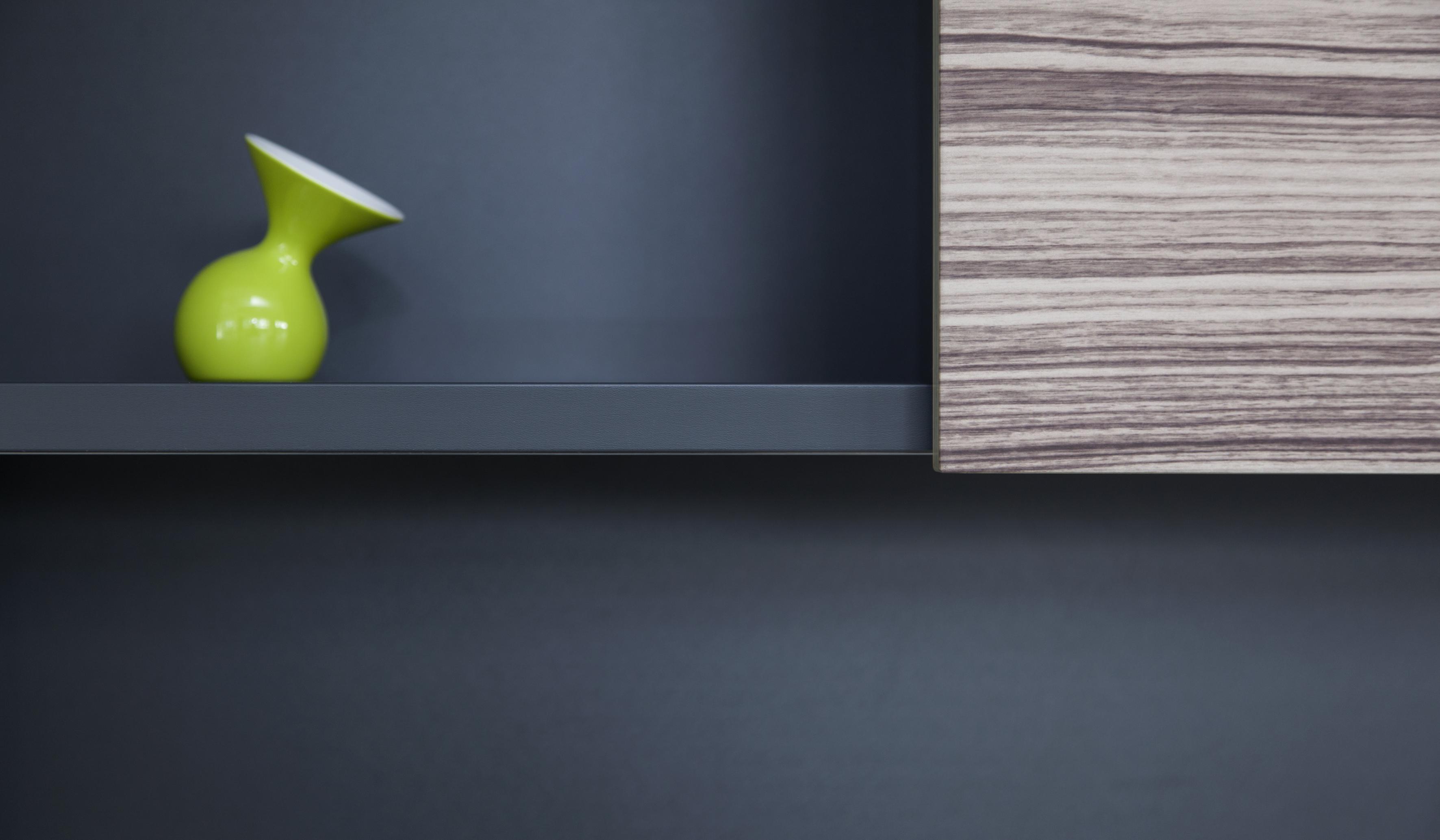 Detail Regalwand schwarz Holz mit grüner Vase