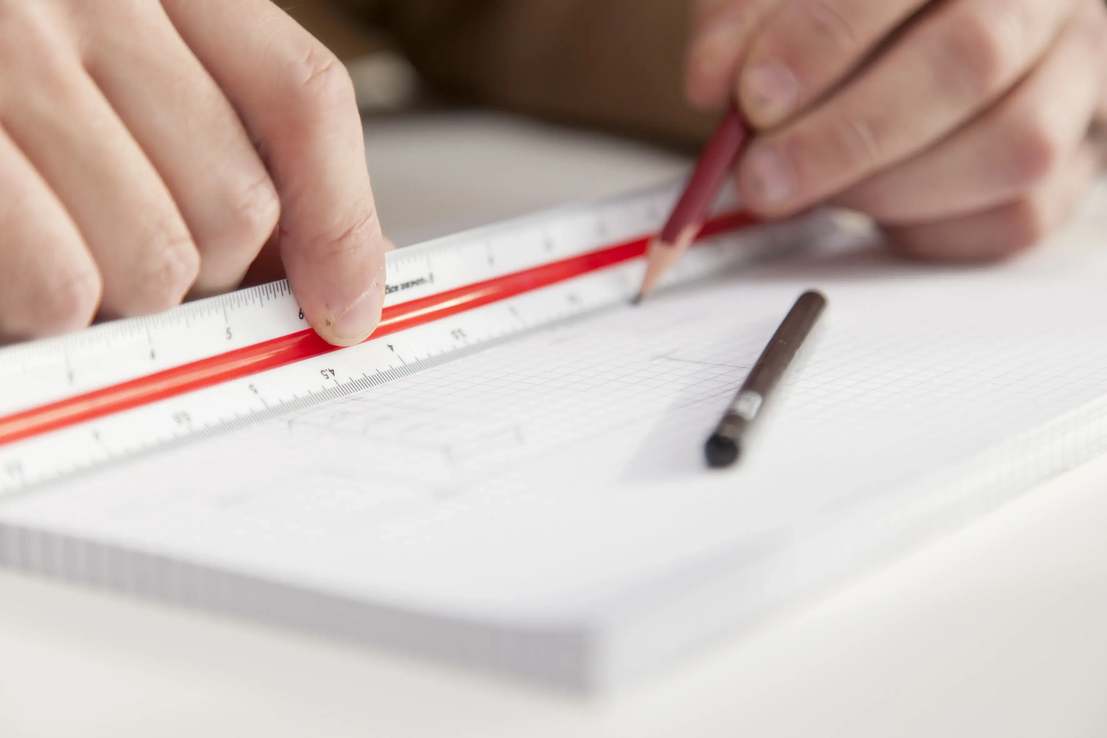 Detail Hände ziehen mit Lineal und Bleistift einen Strich auf einem Block