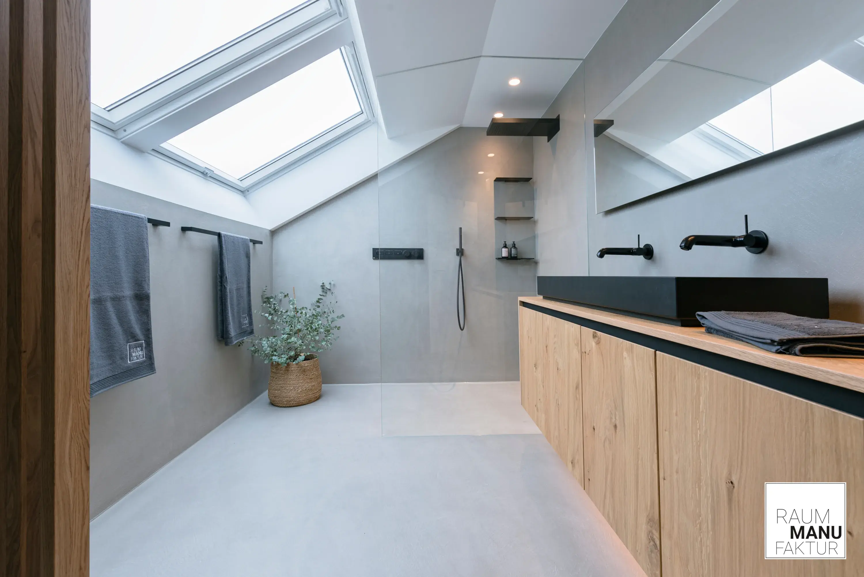 Modernes Badezimmer mit offener Dusche in Betonoptik mit Naturholz und schwarzem Doppelwaschbecken